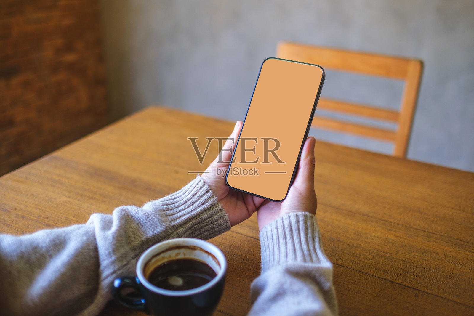 女性手持手机,屏幕为空白桌面,用于模拟展示照片摄影图片