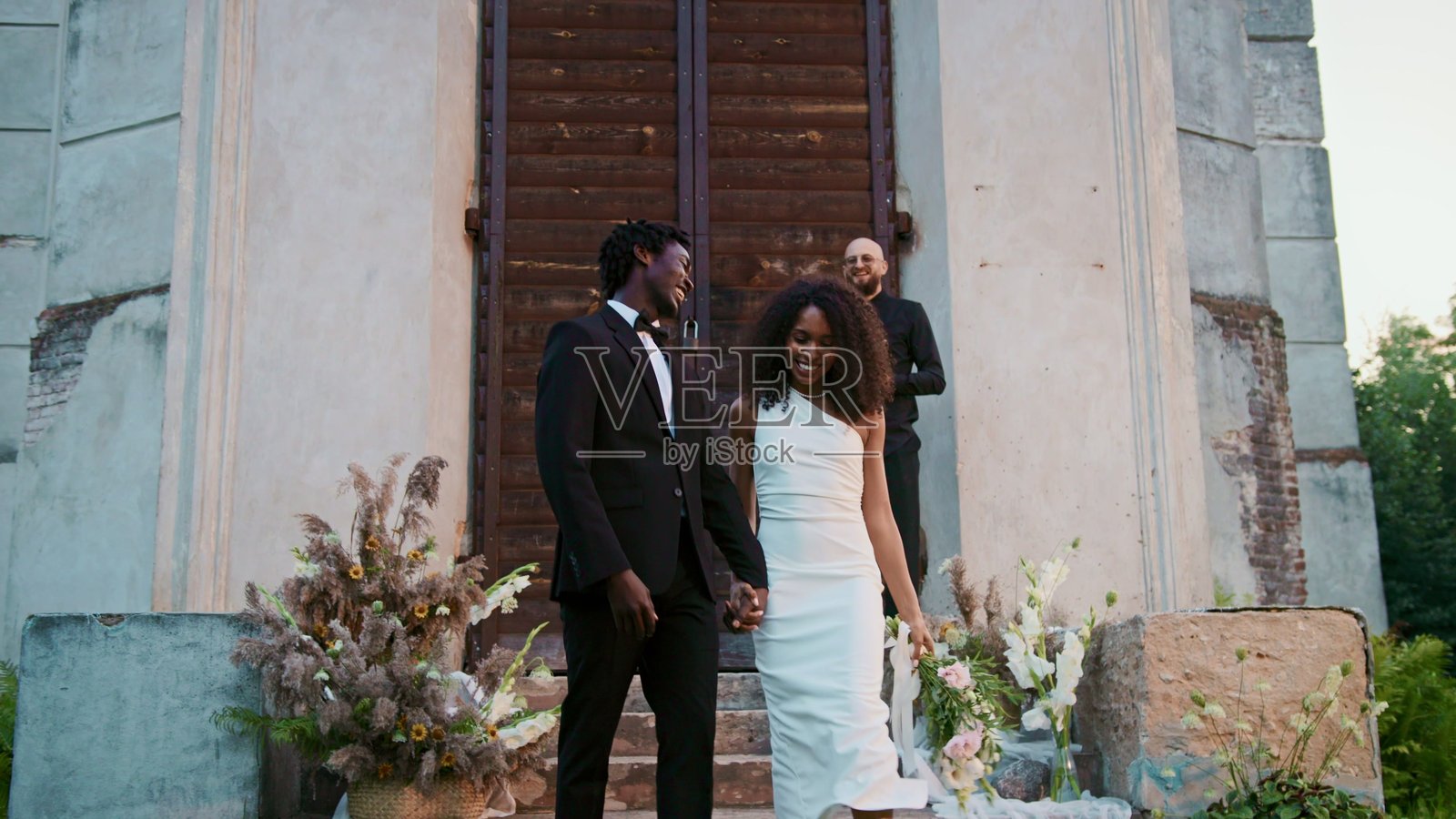 一对幸福的新人走过宾客,接受撒花祝福。照片摄影图片