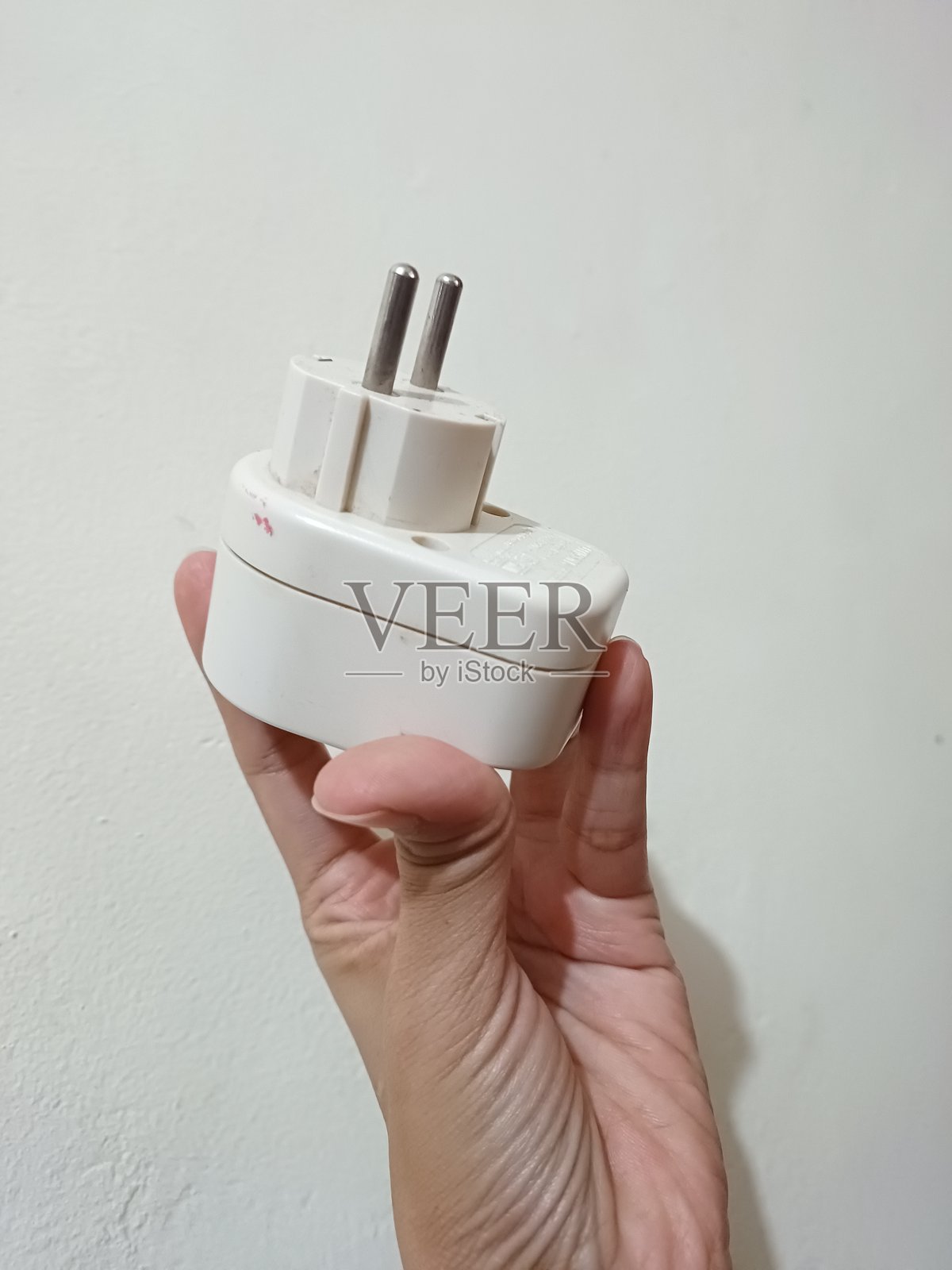 人手握着白色插头照片摄影图片