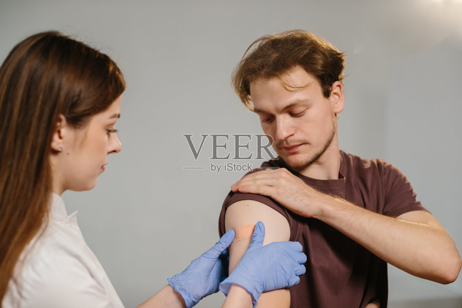 医护人员在接种疫苗后贴上创可贴照片摄影图片