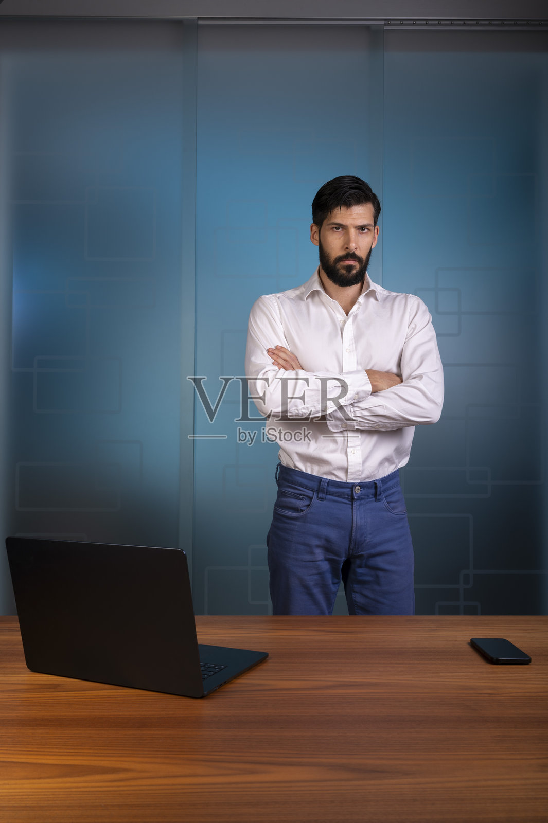 身着白衬衫和蓝色裤子的男士站在现代办公室,代表企业公司照片摄影图片