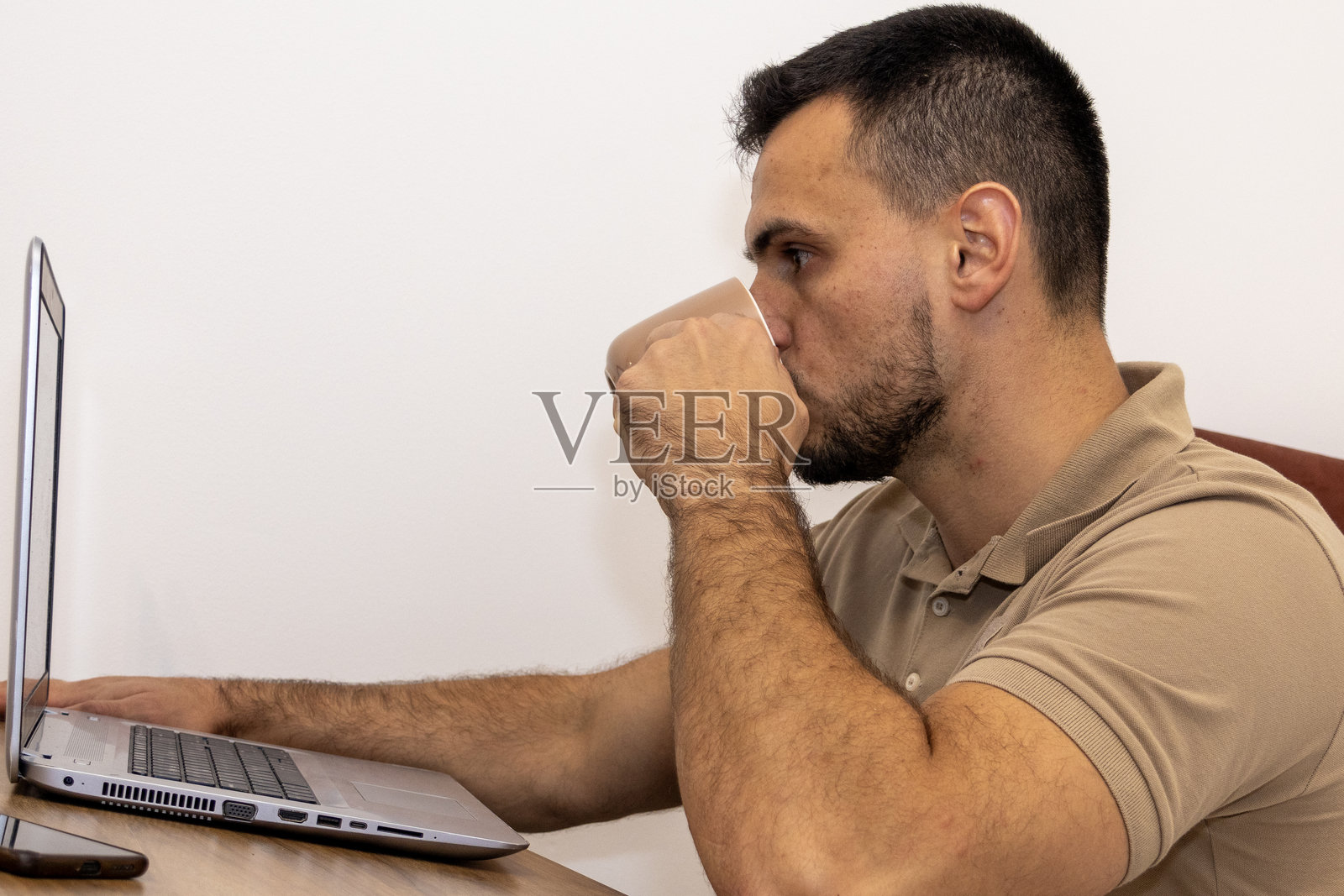 居家办公室里,男子正在用笔记本电脑工作照片摄影图片