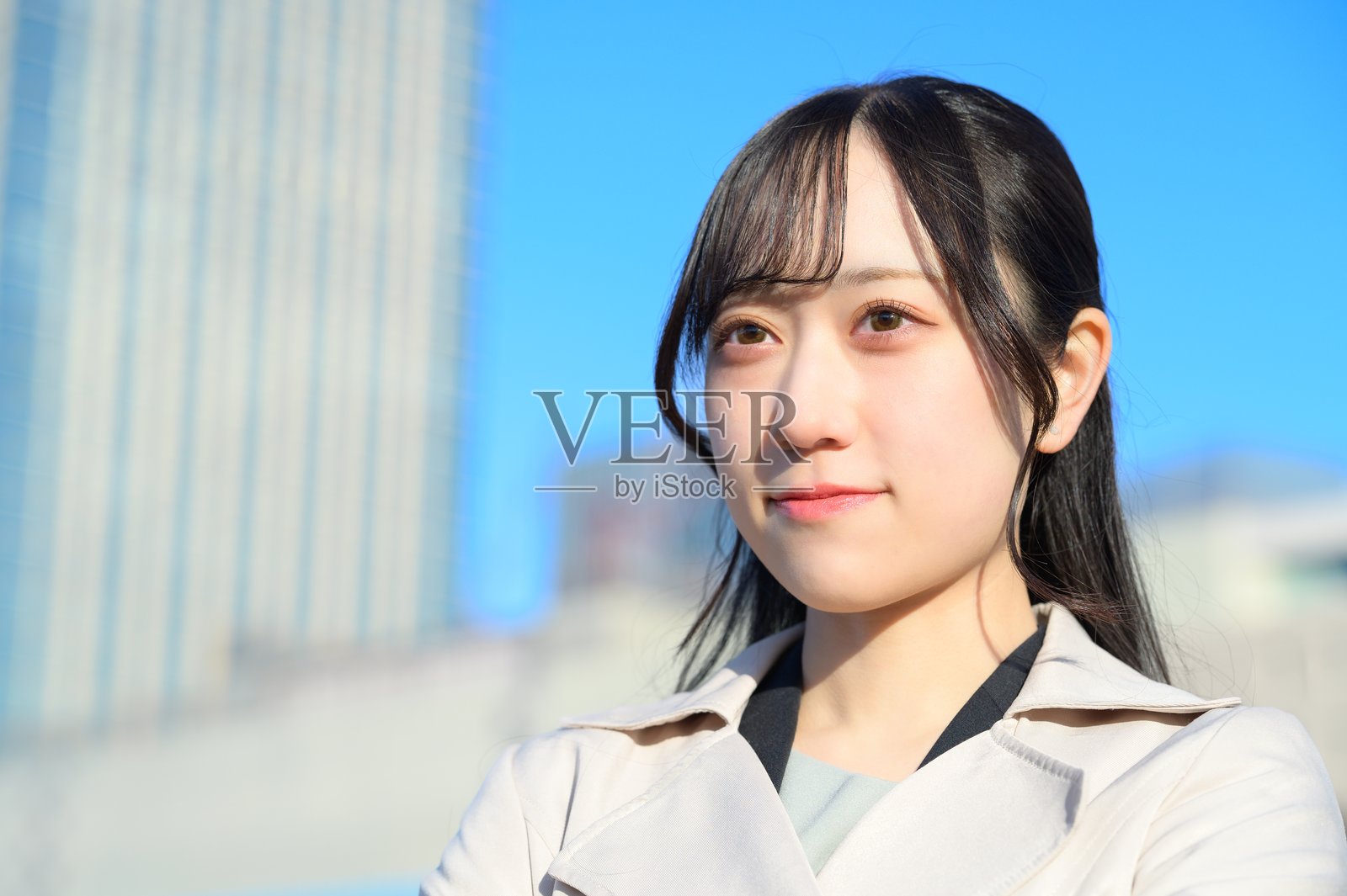 一位女商人站在办公区,凝视着蔚蓝的天空照片摄影图片