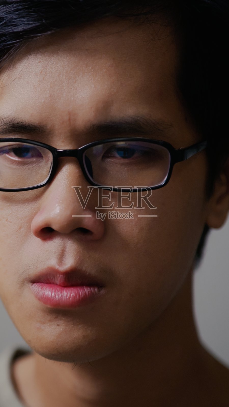 面容严肃的亚洲男性,展现出专注和投入照片摄影图片