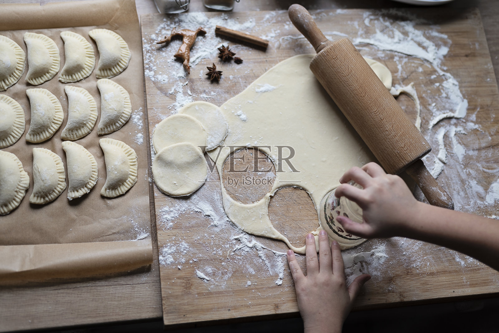 准备食物。一双小小的手正在用生面团制作饺子。厨房里的传统和自制餐点。特写。照片摄影图片