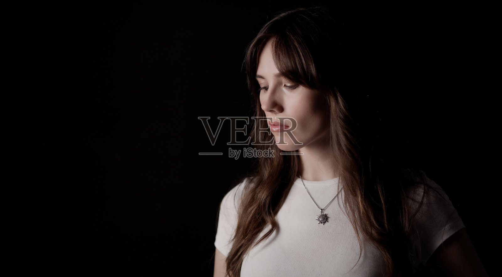 一位女性垂首,脸上带着悲伤和忧郁的神情照片摄影图片