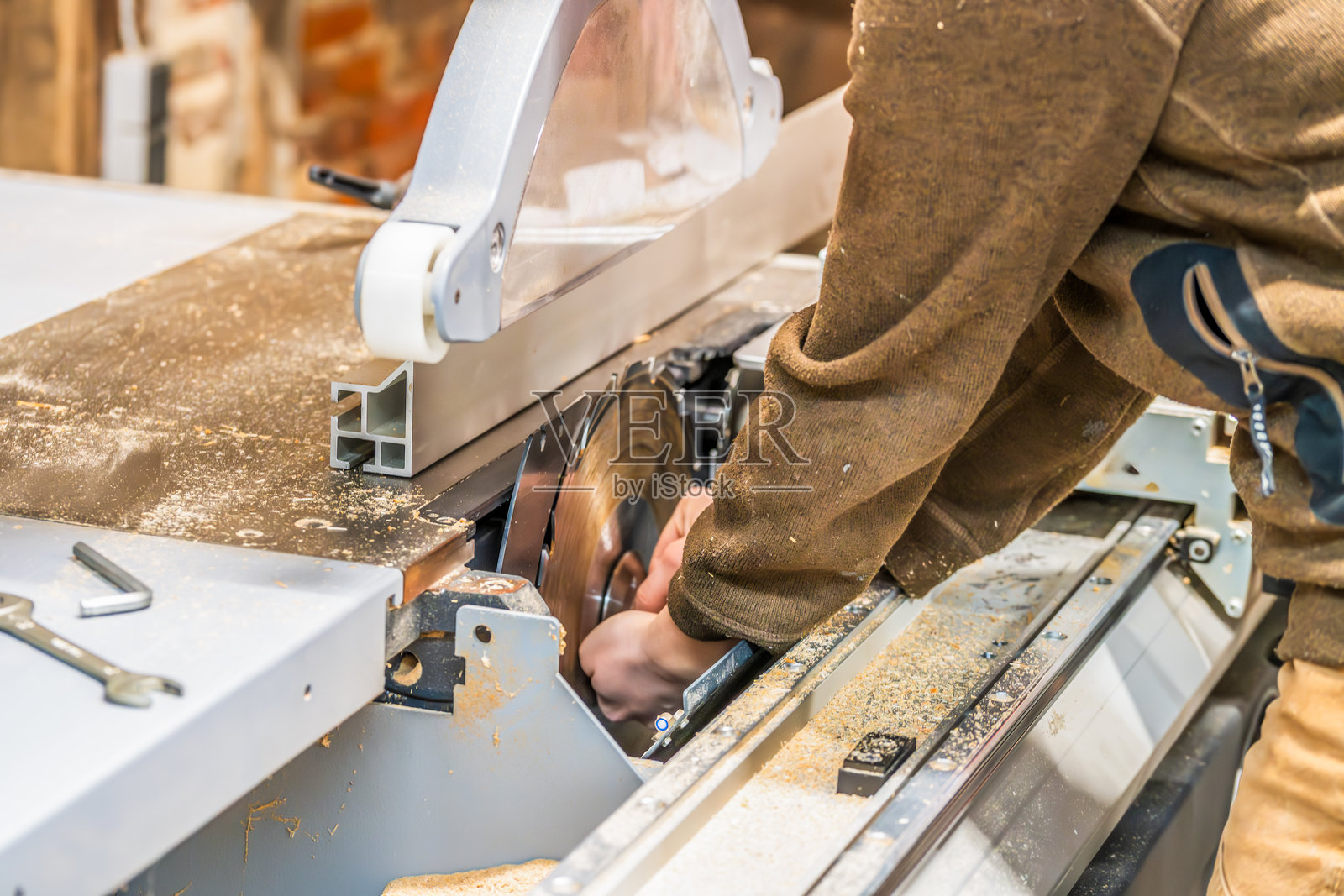 一位女木工正在用台锯引导一块木板照片摄影图片