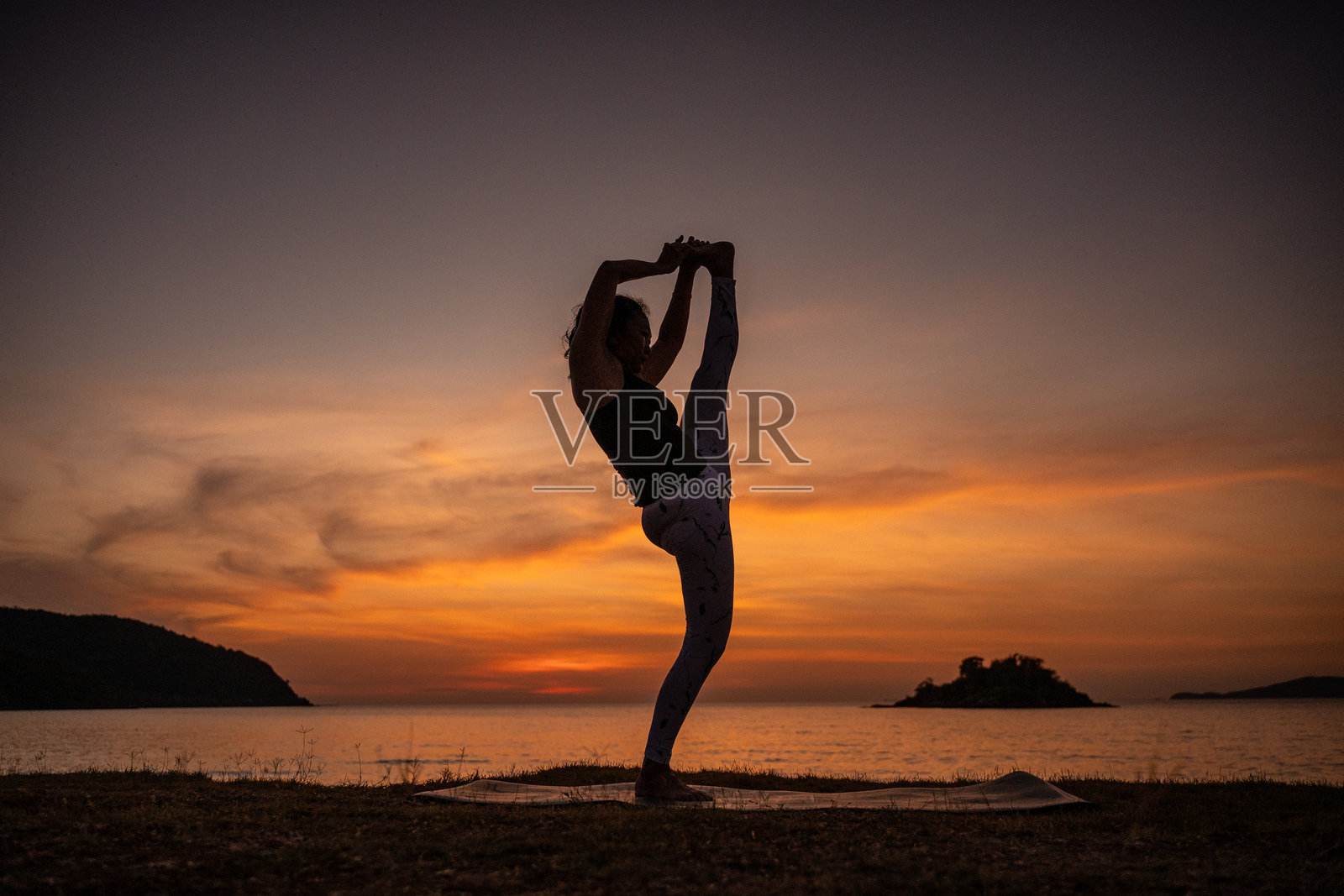 剪影运动女性优雅瑜伽舞王式(Natarajasana),在发光的背景下,完美地体现了冥想、健康和追求生活平衡的精髓。照片摄影图片