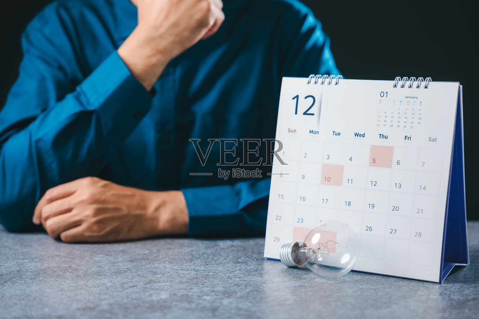 求职灯泡招聘职业学院招聘创业当代机会概念,创意就业招聘人员坐在办公桌日历旁规划未来照片摄影图片