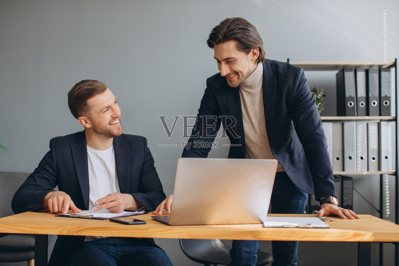 专业商务同事在现代办公室里协作使用笔记本电脑,共同规划策略并分享想法。照片摄影图片