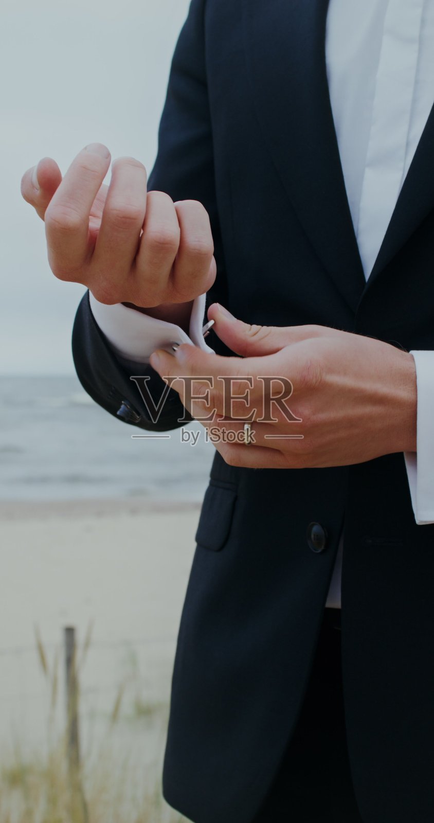 新郎正在为衬衫系袖扣 - 婚礼照片摄影图片