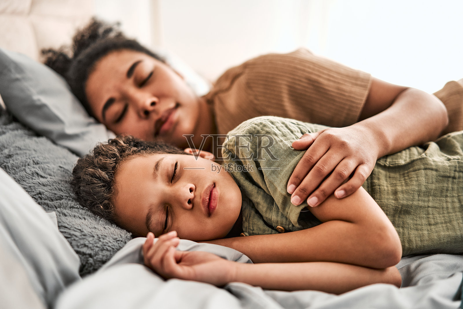 一个孩子安详地睡在母亲身边,享受着平静健康的美好休息。照片摄影图片