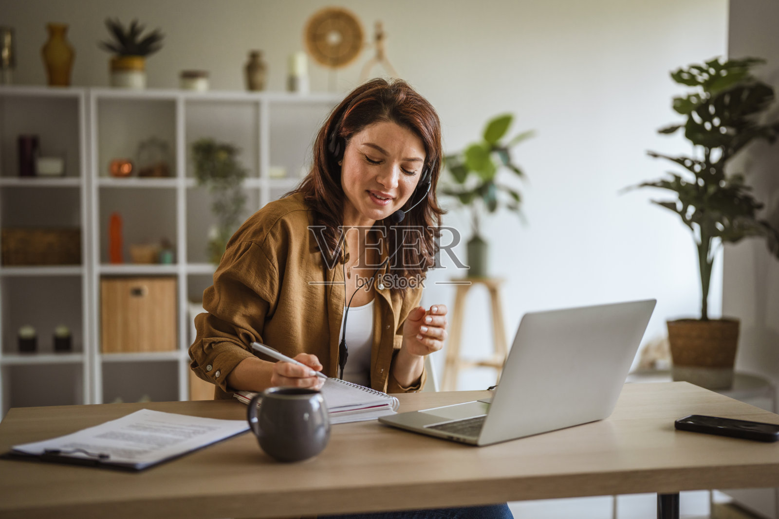 女性在进行视频通话时使用耳机远程工作照片摄影图片