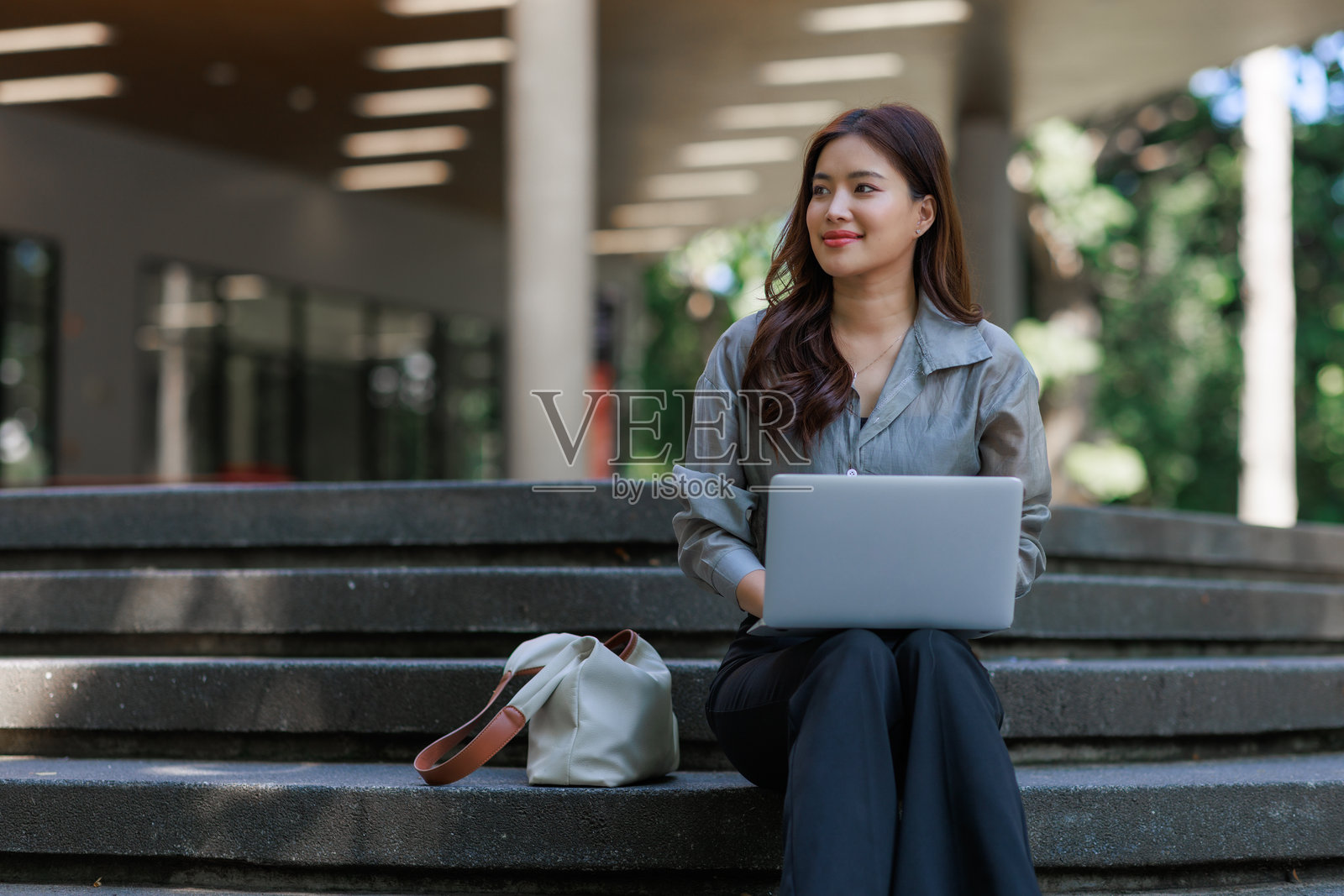 亚洲女性在户外用笔记本电脑工作照片摄影图片