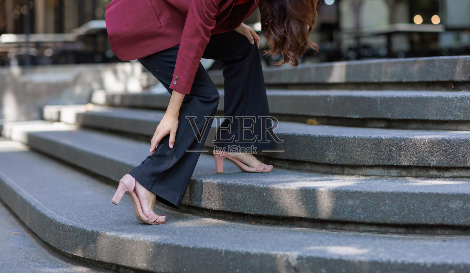 女商人爬楼梯时腿部疼痛照片摄影图片