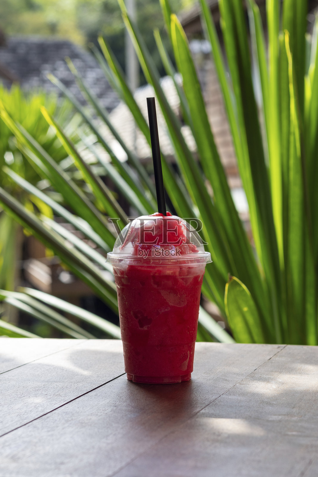 泰国热带绿色背景下的清爽红色冰沙照片摄影图片