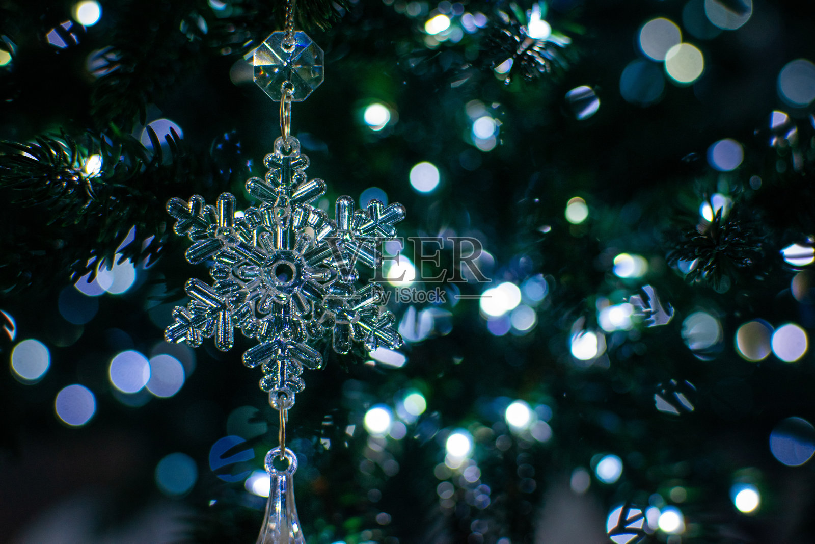 节日圣诞树上的闪亮水晶雪花挂饰,背景有散景灯光照片摄影图片