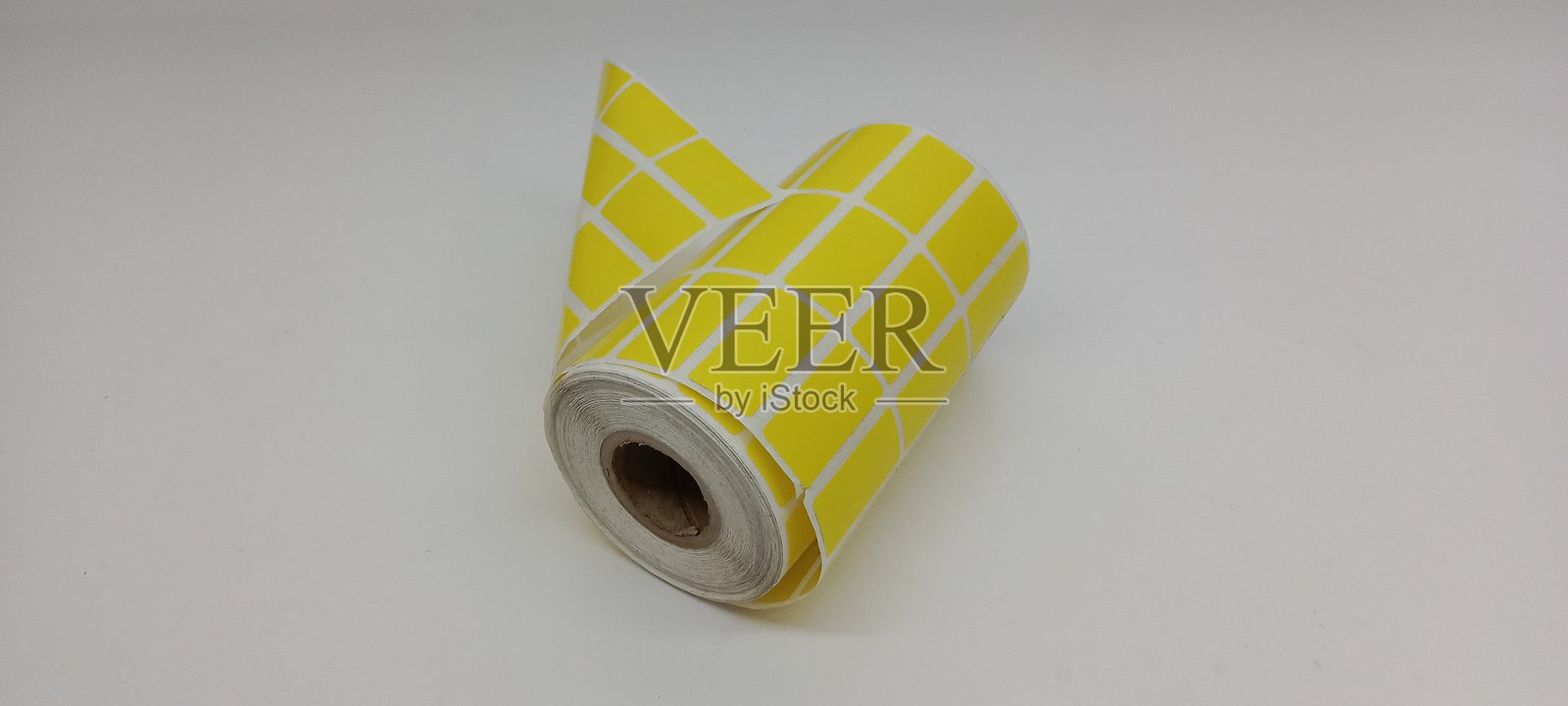 黄色的条形码贴纸卷,孤立在白色背景上。照片摄影图片