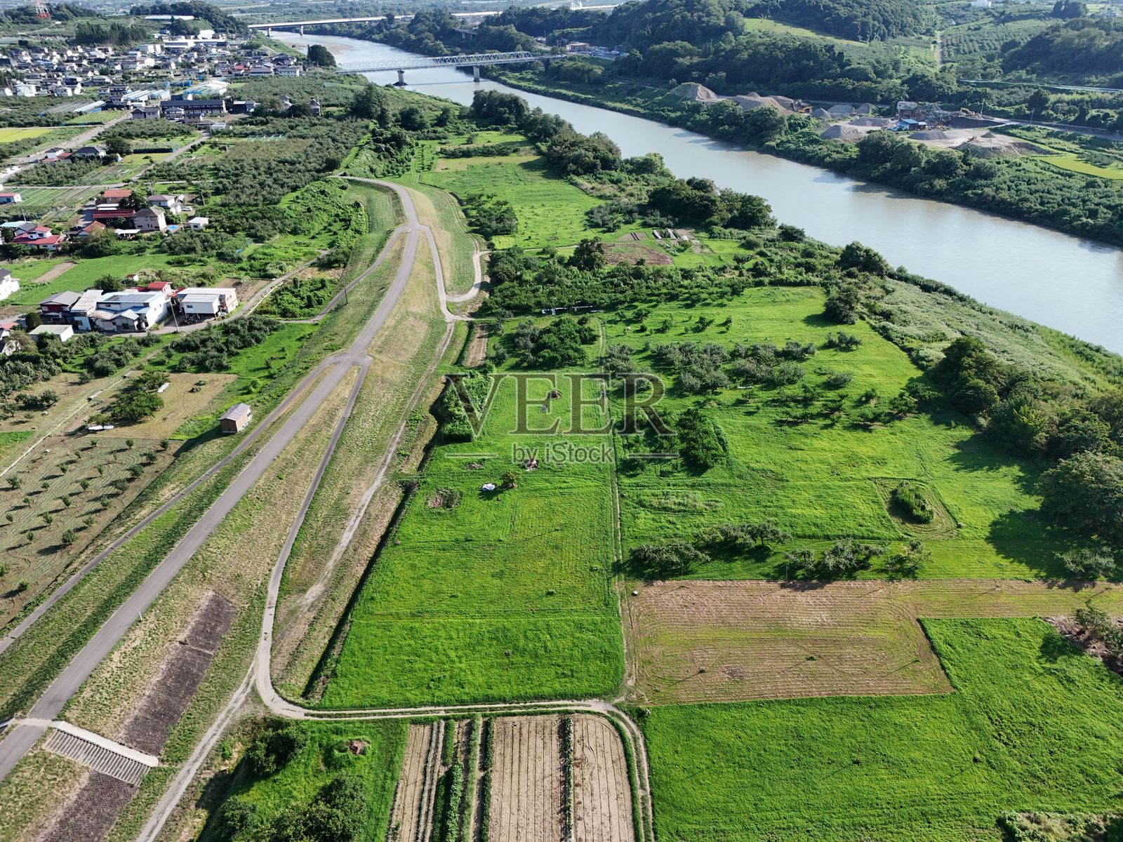一条河流穿过绿色的田野照片摄影图片
