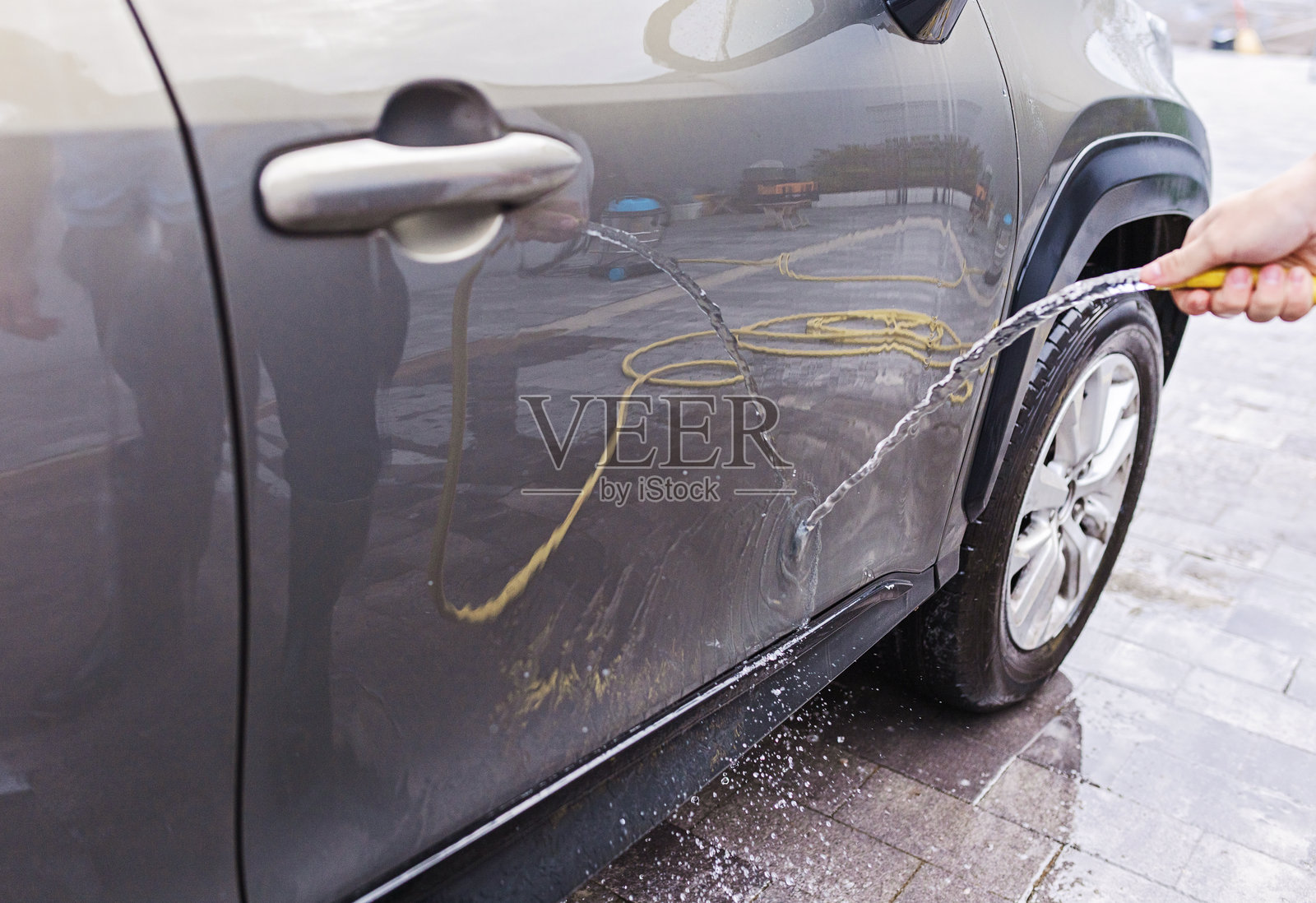 阳光明媚的日子里,汽车被水管清洗的特写镜头照片摄影图片