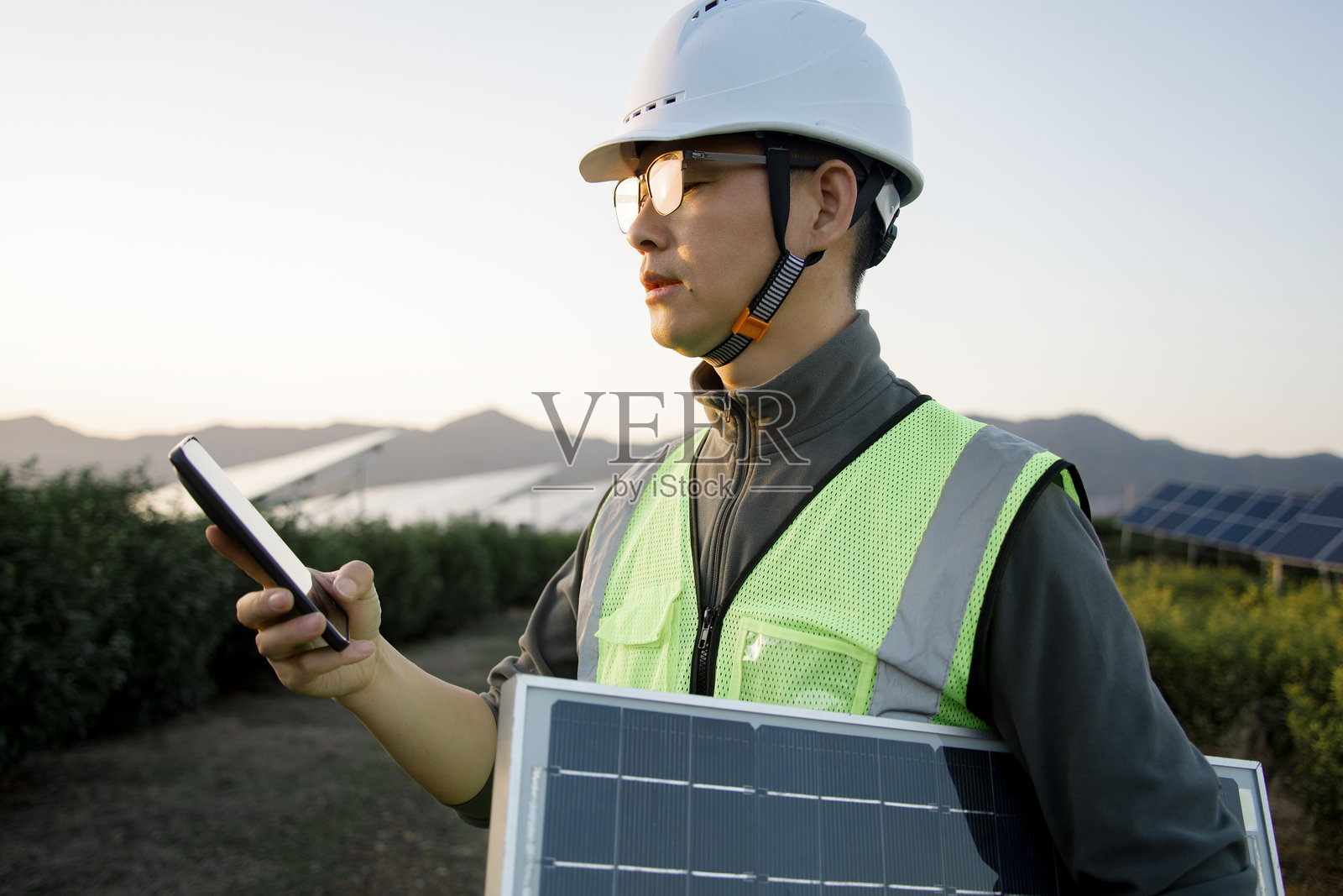 光伏工程师手持设备检查太阳能板照片摄影图片