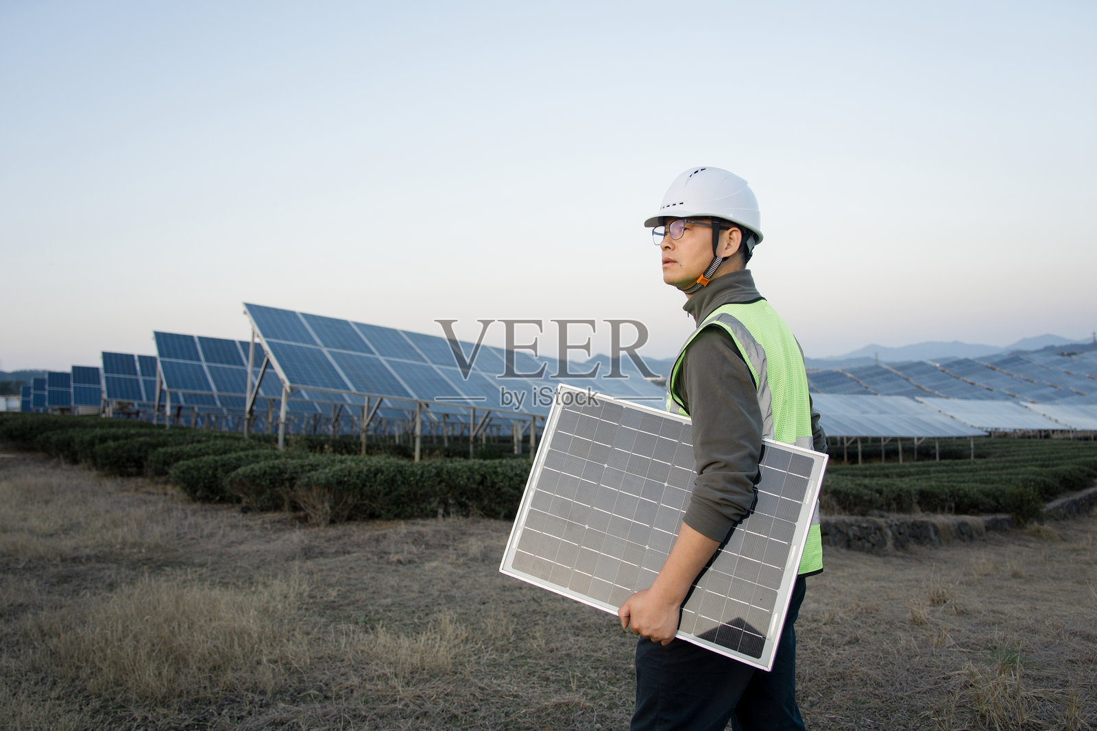 工程师持光伏板巡视太阳能电站照片摄影图片
