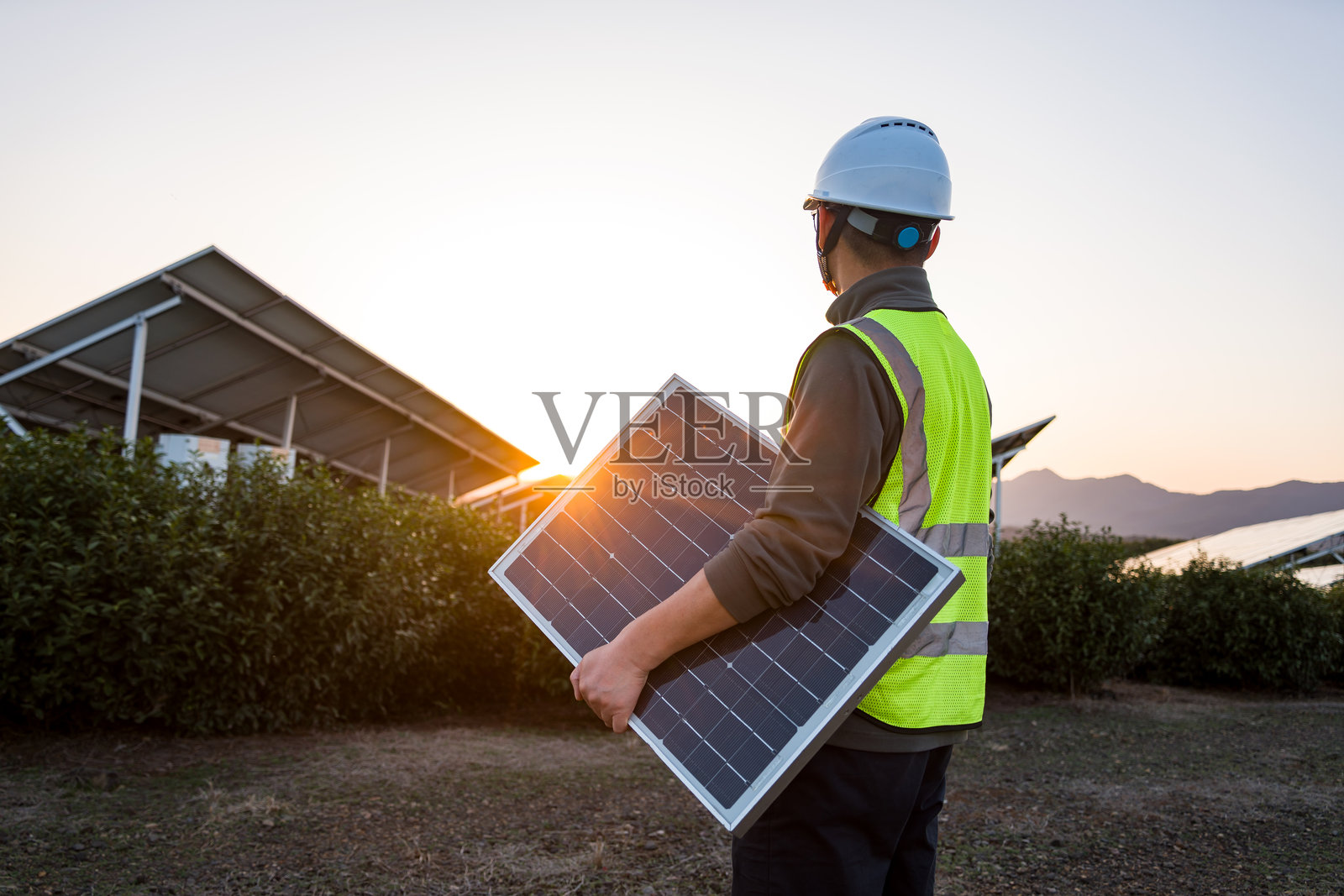 工程师拿着光伏板在太阳能发电基地照片摄影图片