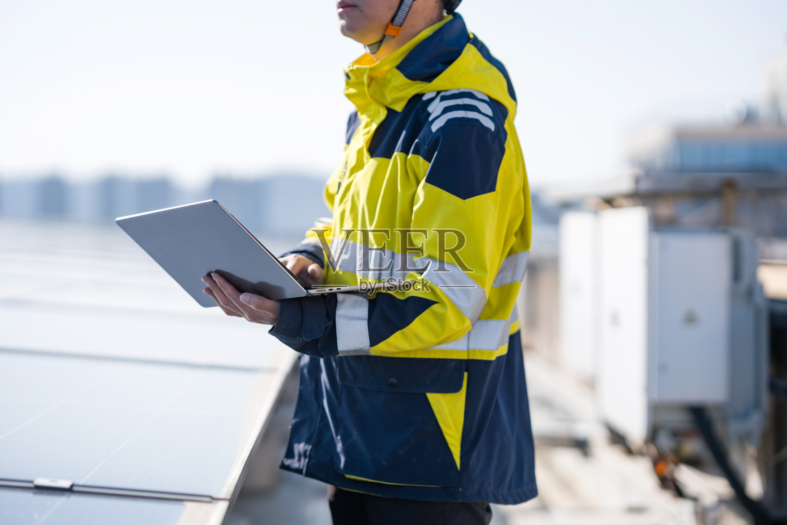 工程师穿反光服持笔记本检查光伏板照片摄影图片