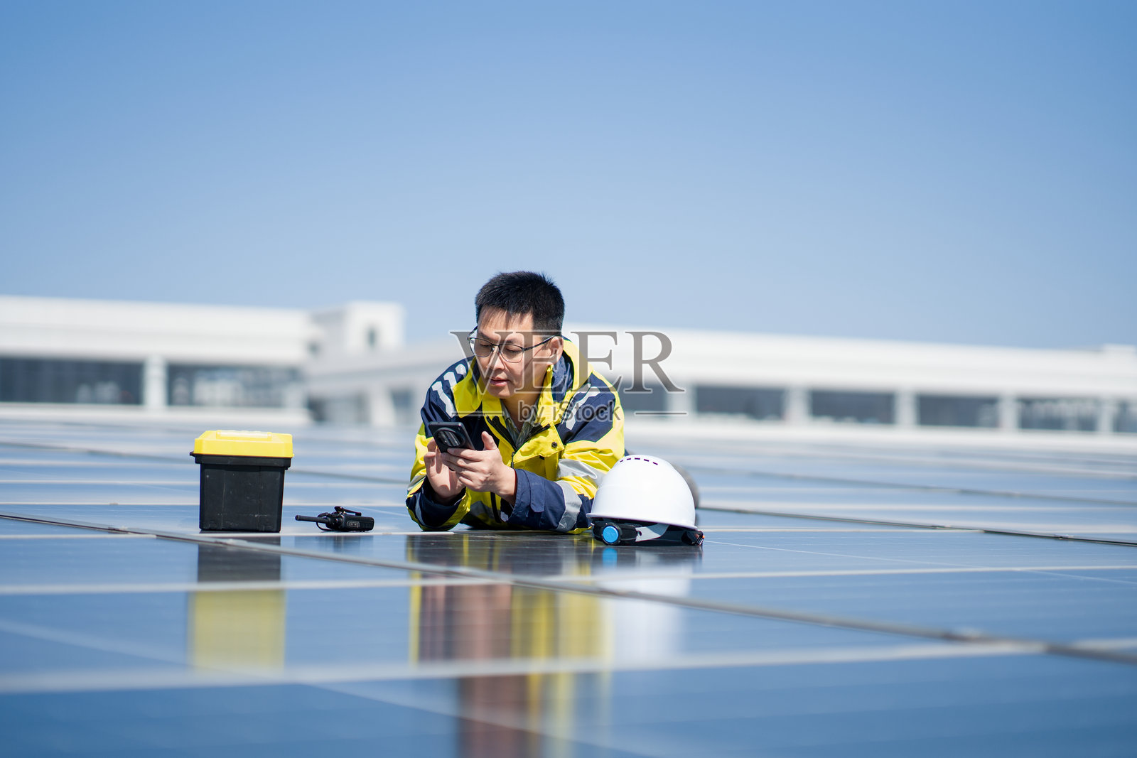 光伏电站工程师俯身检查设备数据照片摄影图片