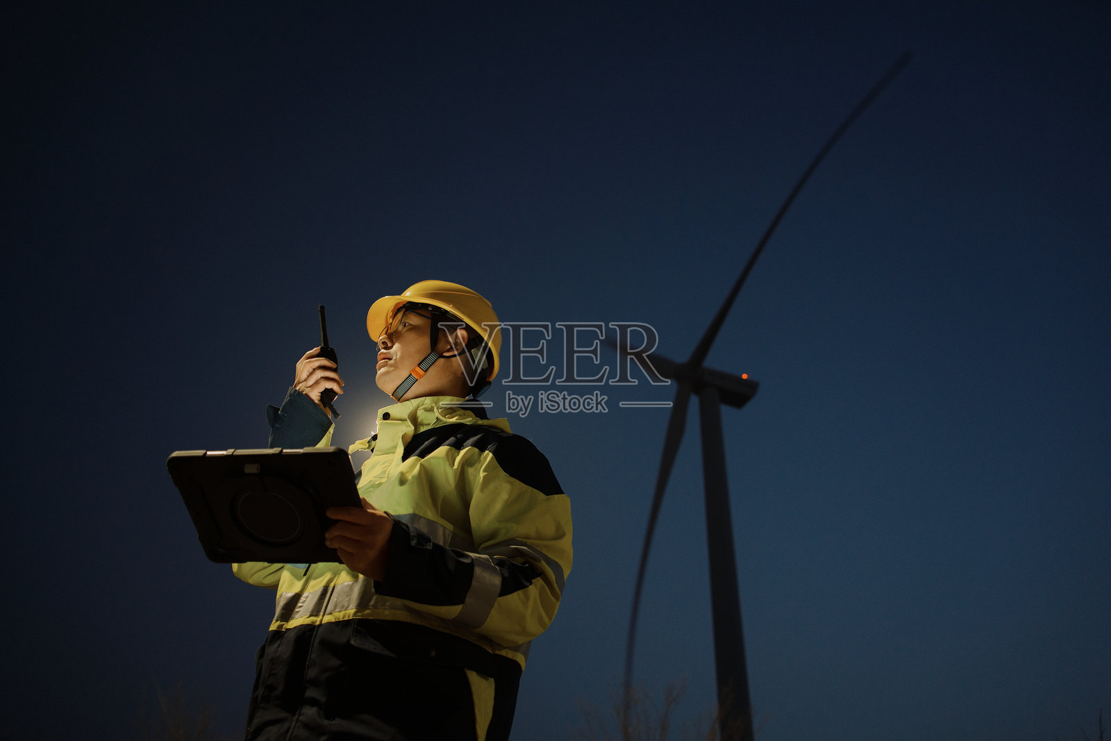 风电场夜巡工程师手持对讲机查设备照片摄影图片