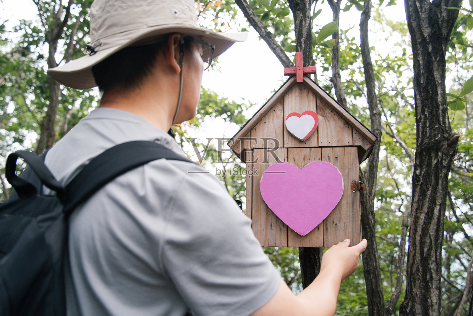 男子户外看爱心木屋照片摄影图片