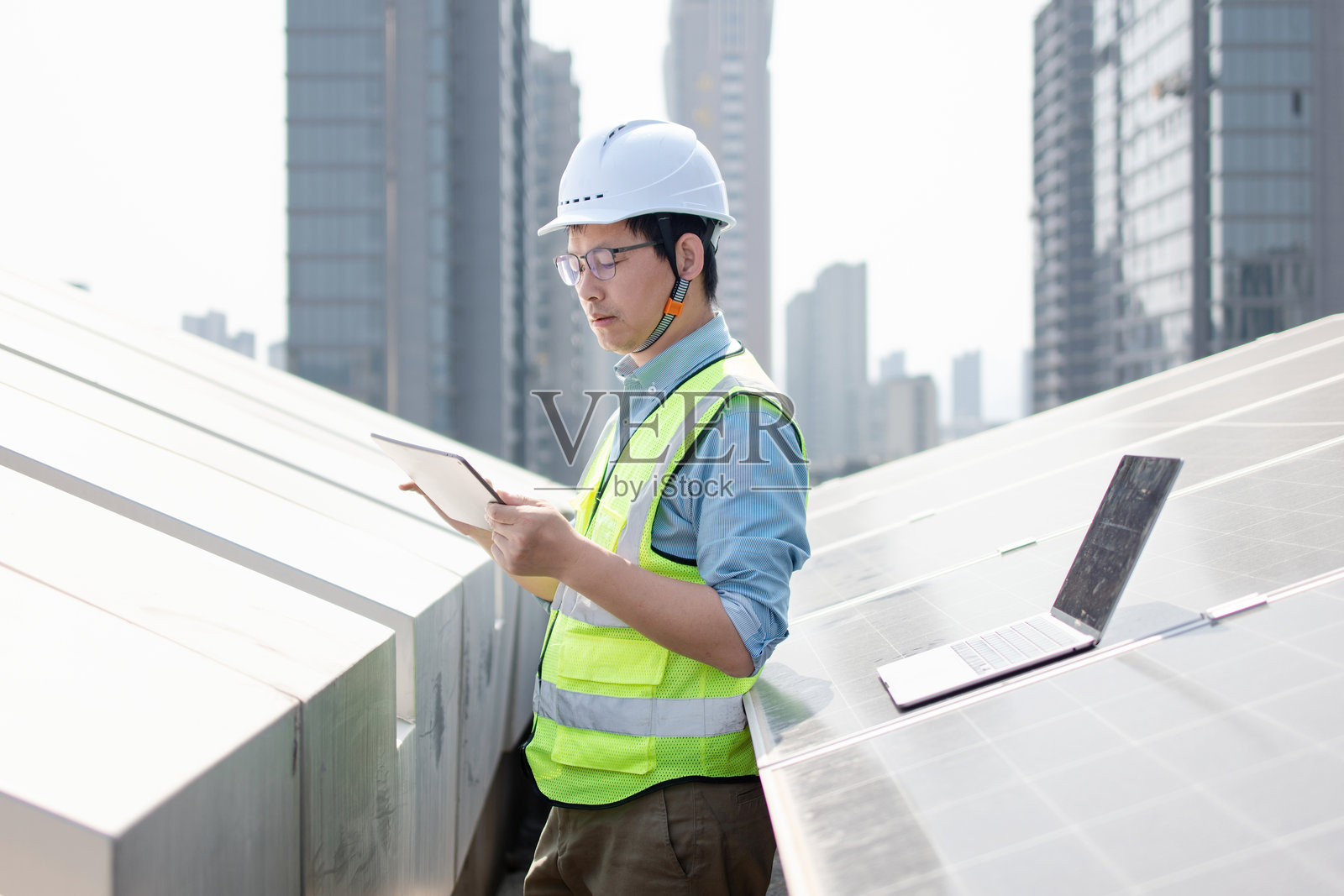 工程师戴安全帽用平板检查太阳能板照片摄影图片