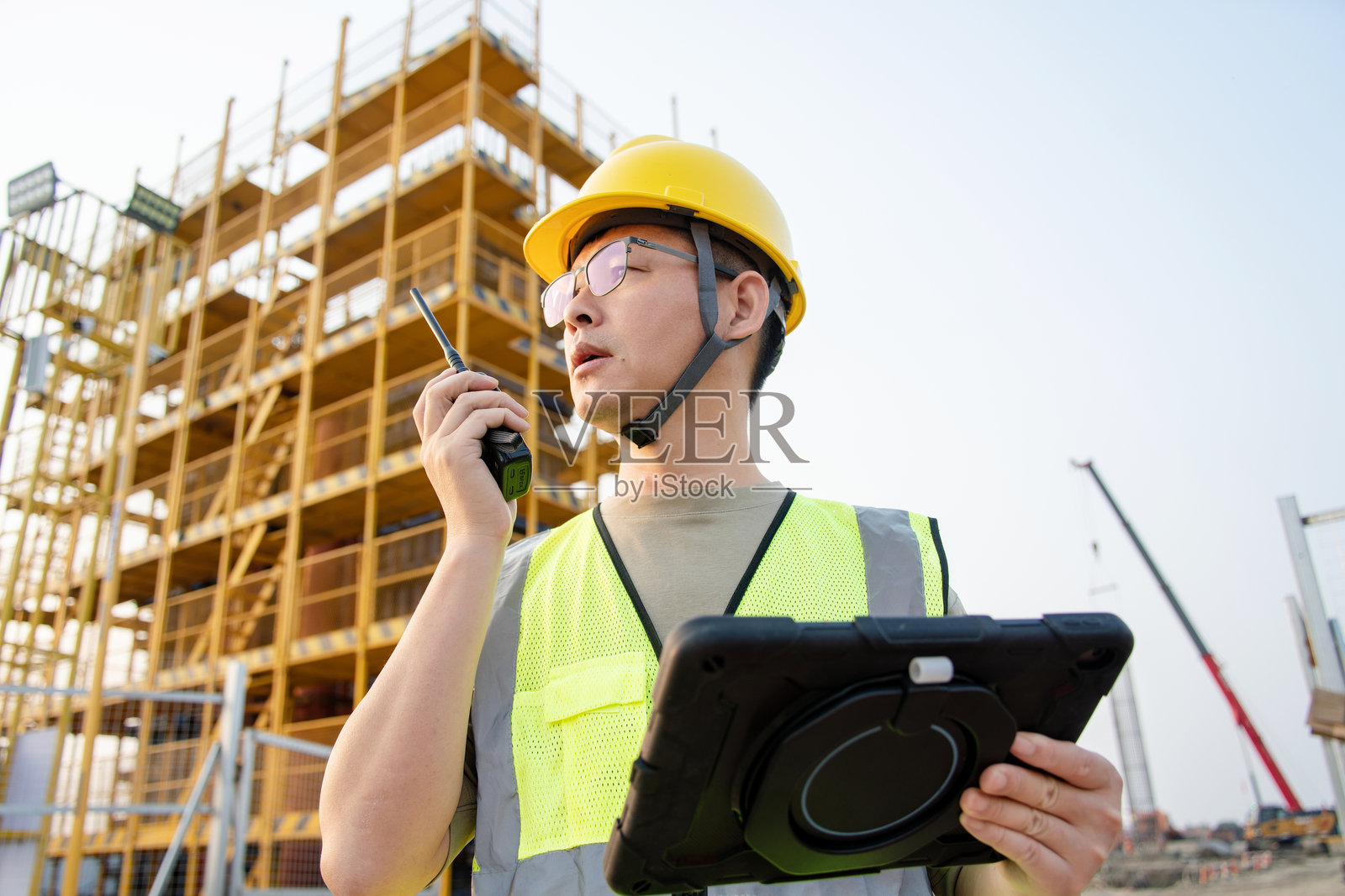 工地工程师持对讲机与平板照片摄影图片