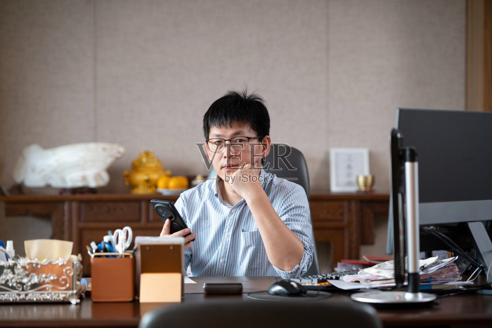 办公桌上思考的商务男士照片摄影图片