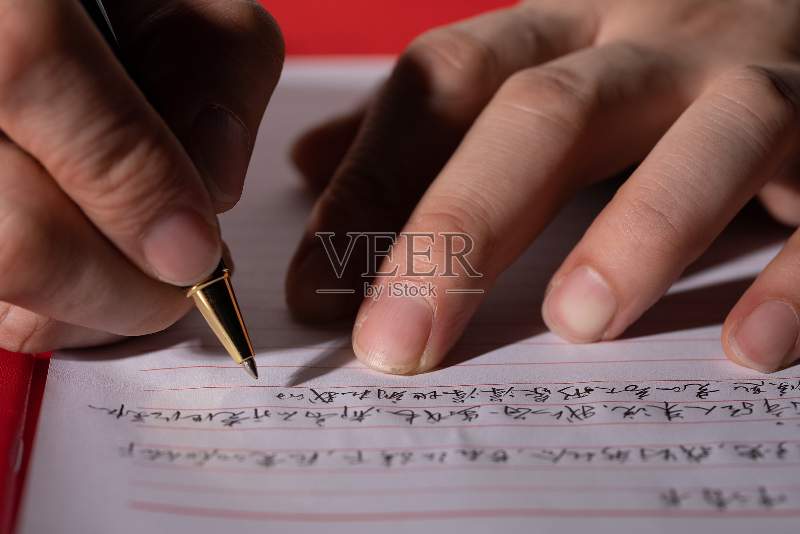 手执笔在纸上书写文字照片摄影图片