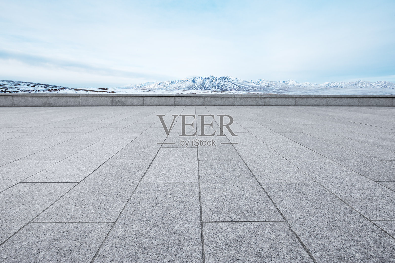 灰色石板广场前景延伸至雪山背景的开阔景观照片摄影图片