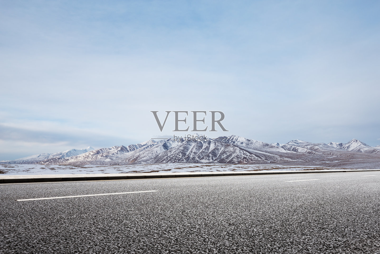 空旷沥青公路延伸至雪山背景下的高原荒野景观照片摄影图片