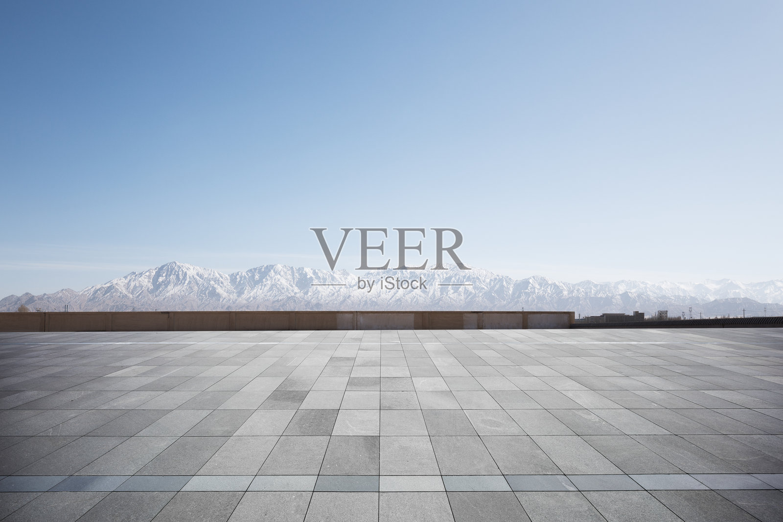 空旷灰色地砖广场远眺雪山山脉晴空背景照片摄影图片
