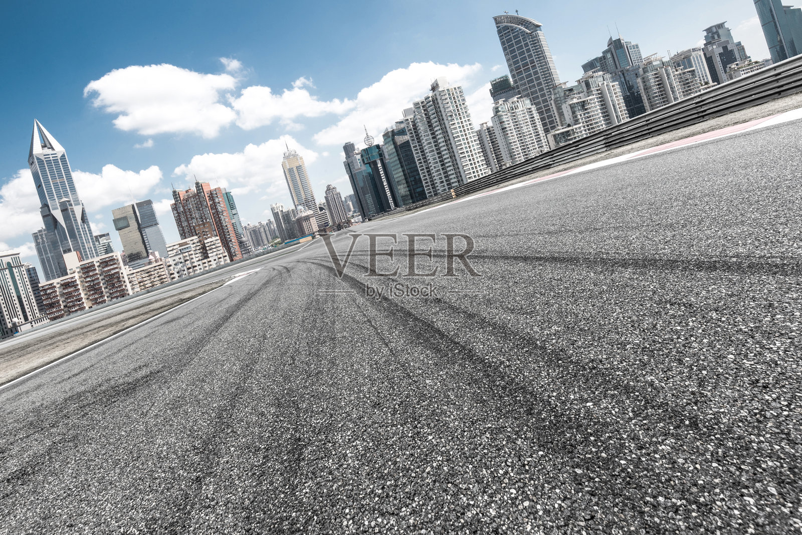 城市天际线背景下的空旷沥青赛道路面特写照片摄影图片
