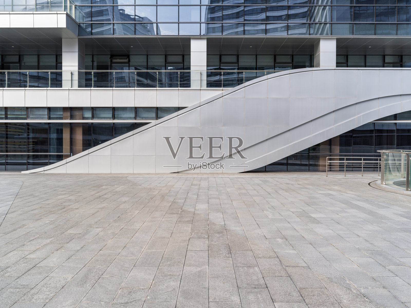 现代建筑前弧形金属坡道与铺装广场照片摄影图片