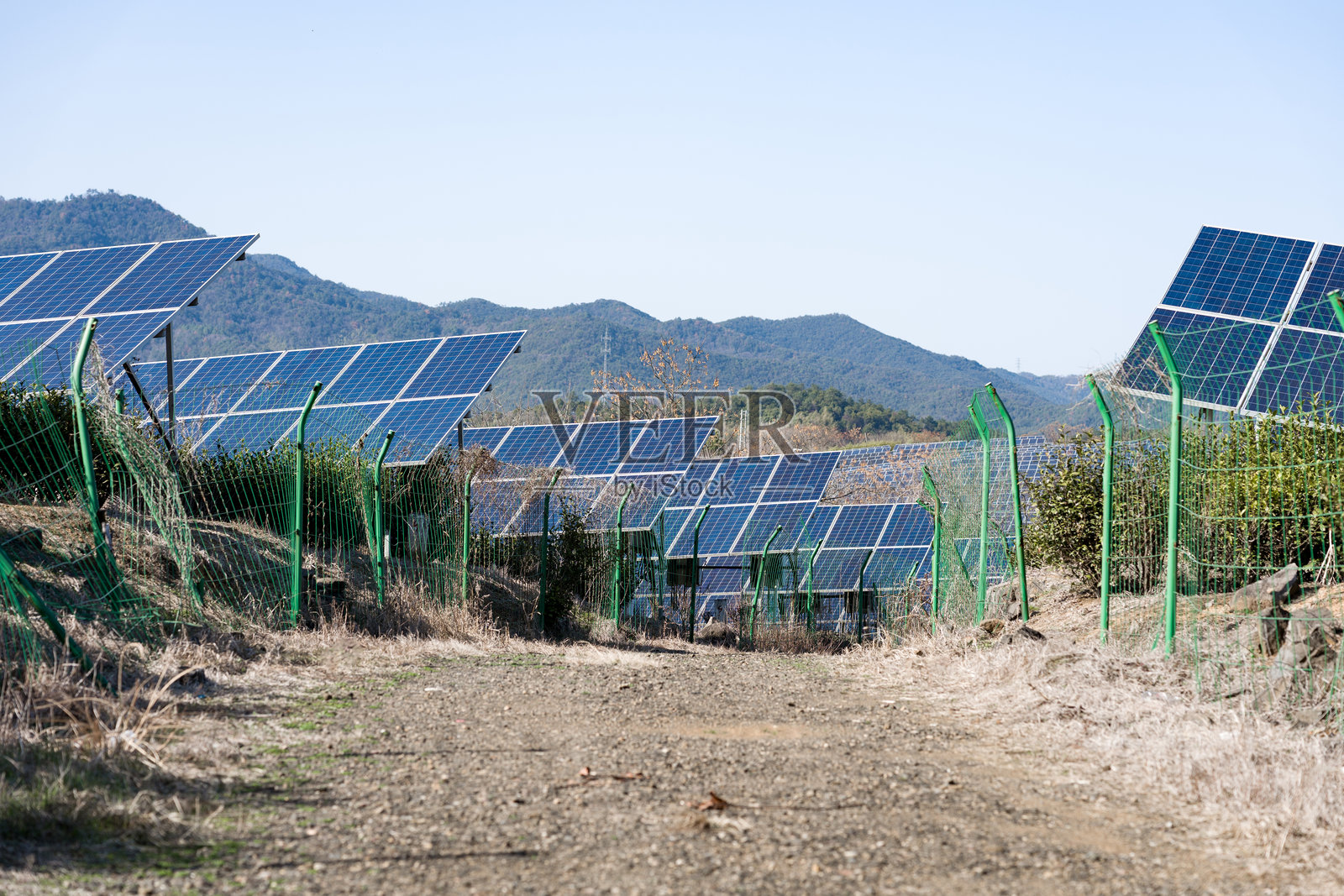 山地光伏电站阵列与绿色围栏景观照片摄影图片