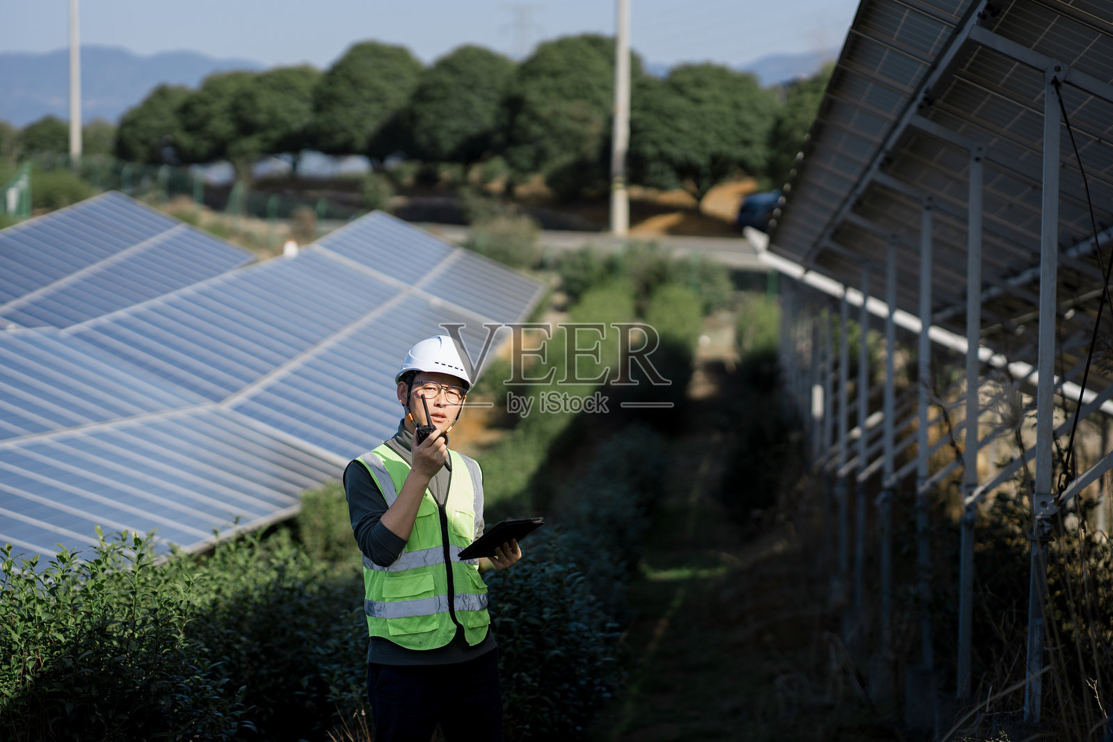 光伏电站巡检员手持对讲机检查设备照片摄影图片