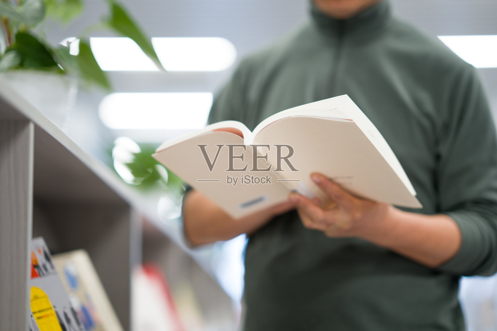 图书馆内读者专注阅读书籍场景照片摄影图片