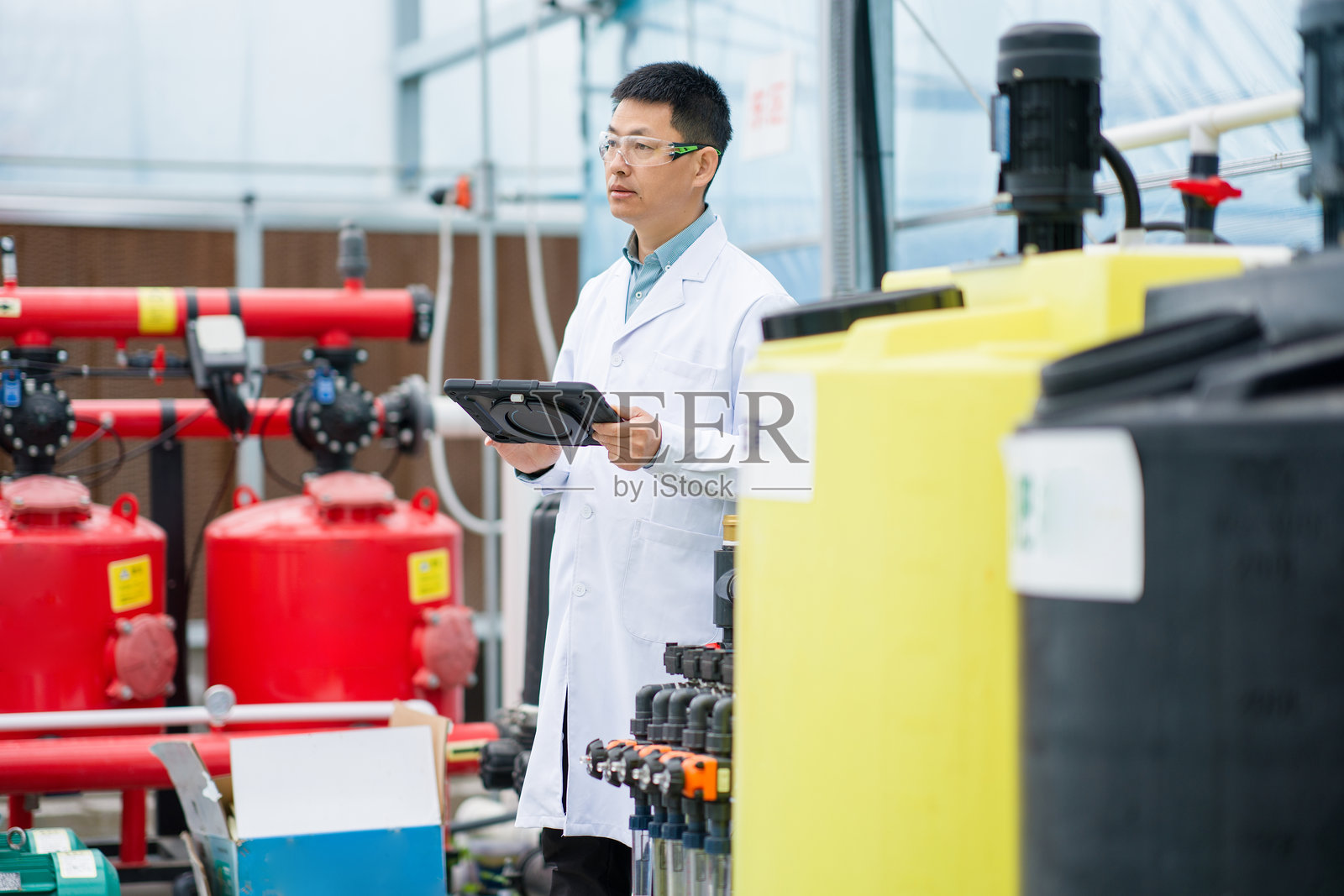 科研人员手持平板检查水处理设备照片摄影图片