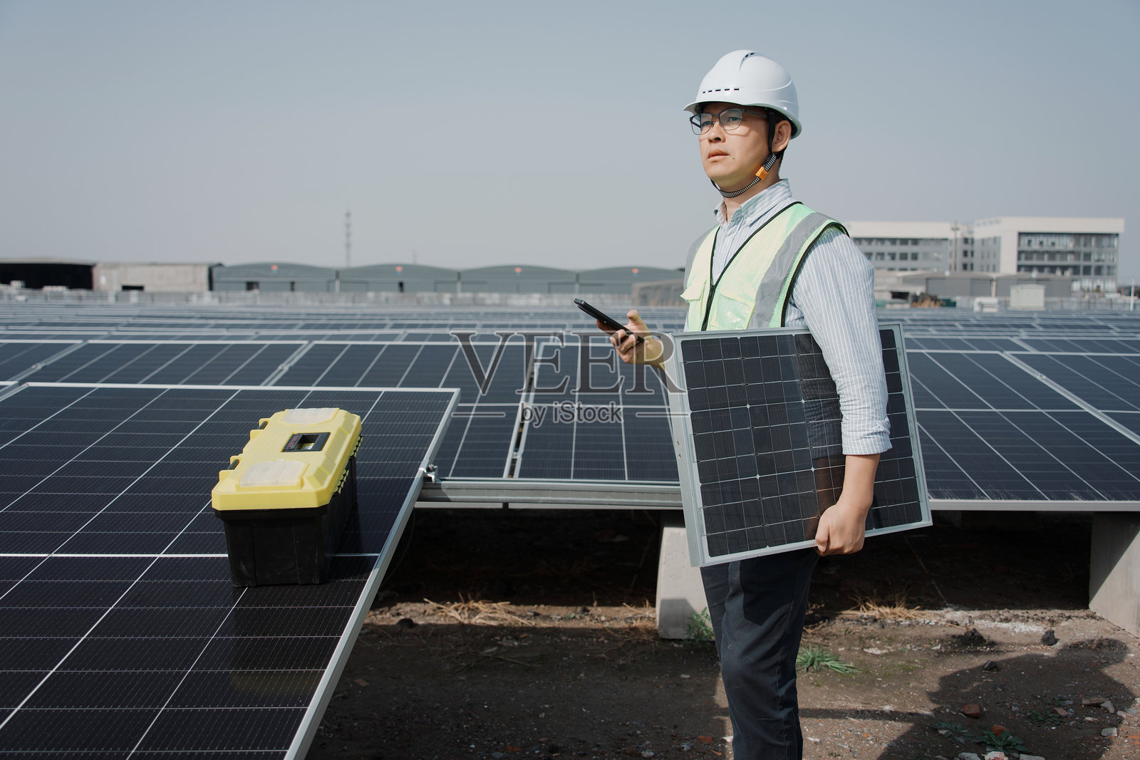 工程师手持光伏板检查太阳能电站照片摄影图片
