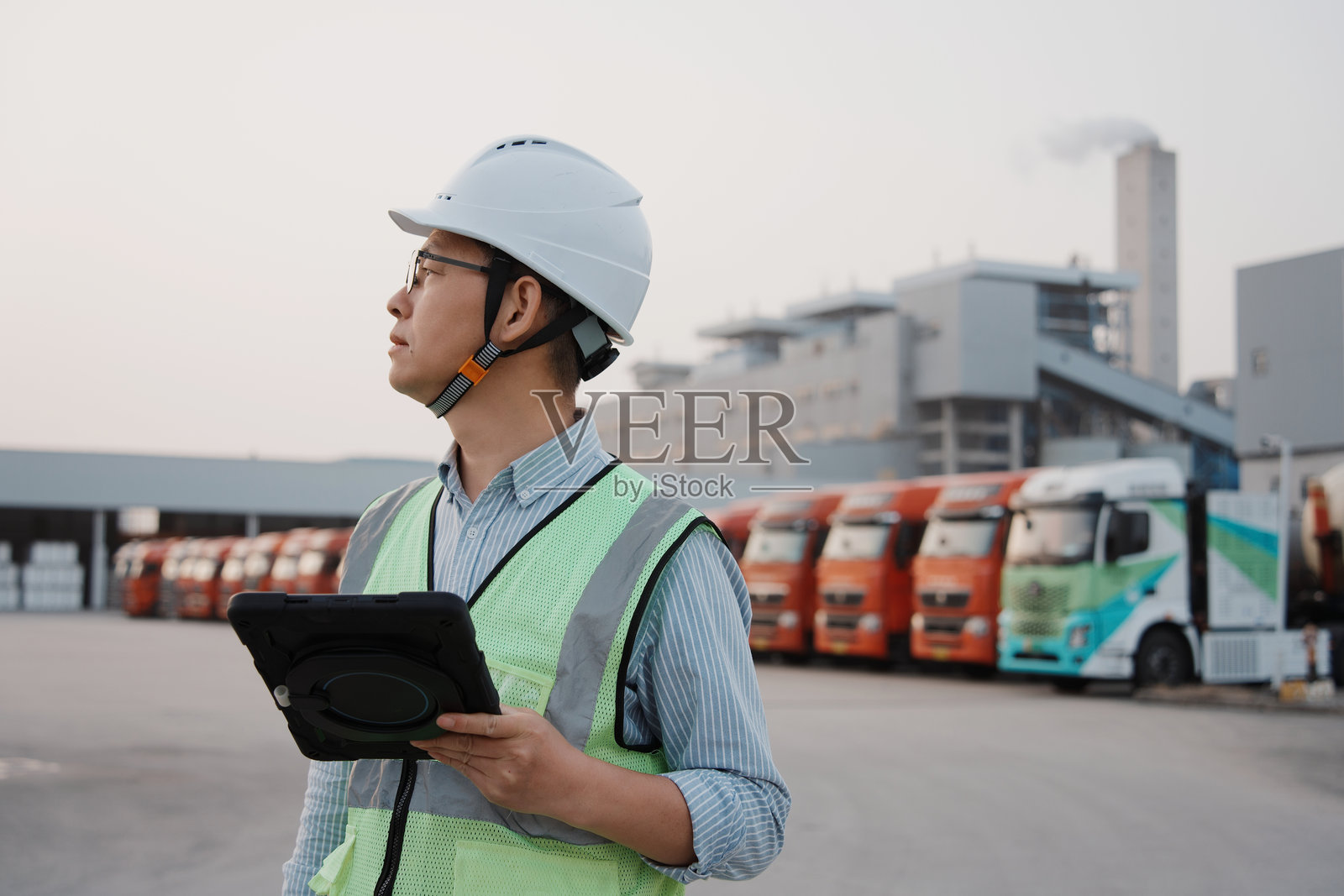 工厂园区工程师持平板巡查货车队列照片摄影图片