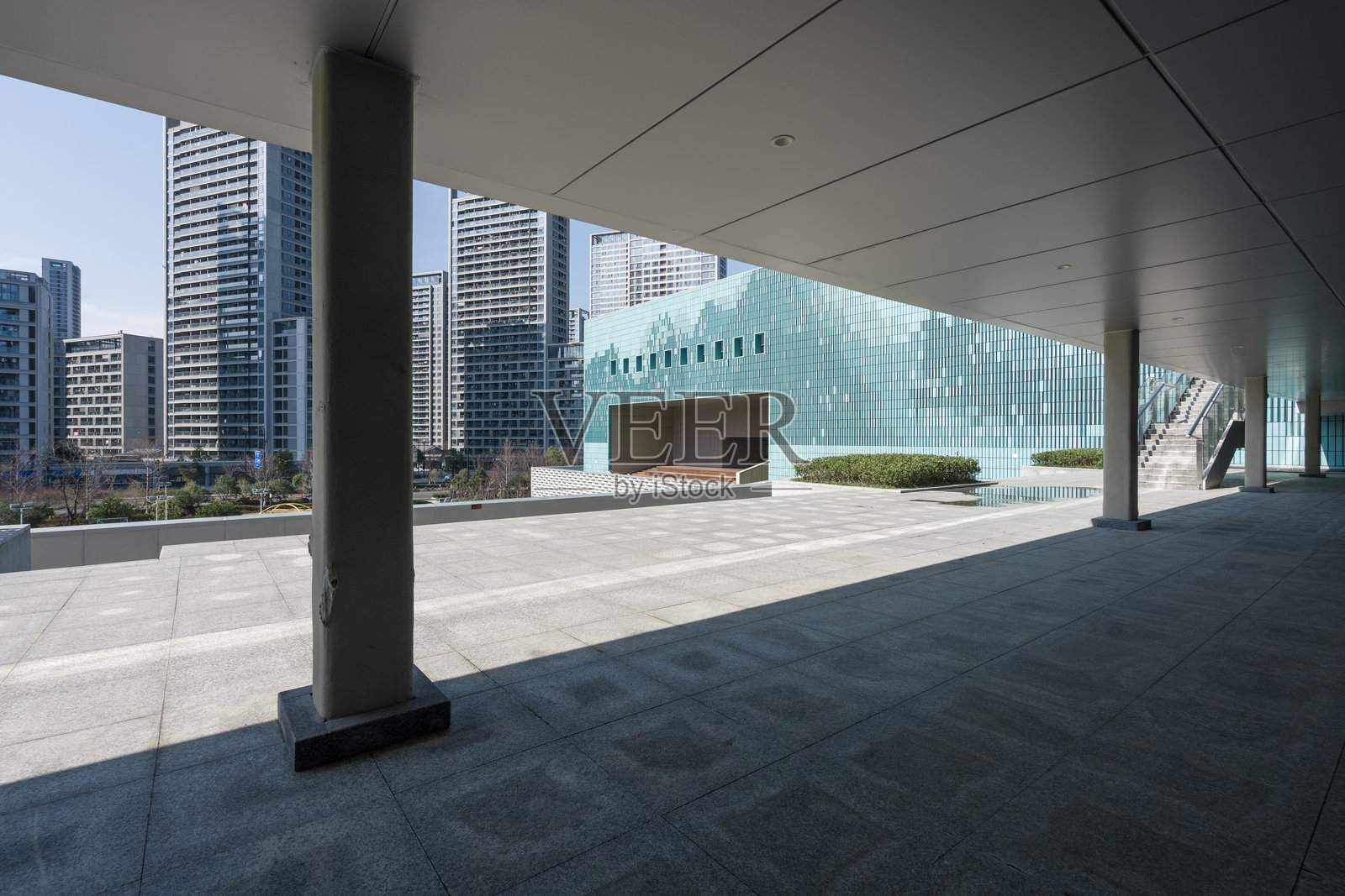 现代城市建筑群下空旷广场与玻璃幕墙照片摄影图片