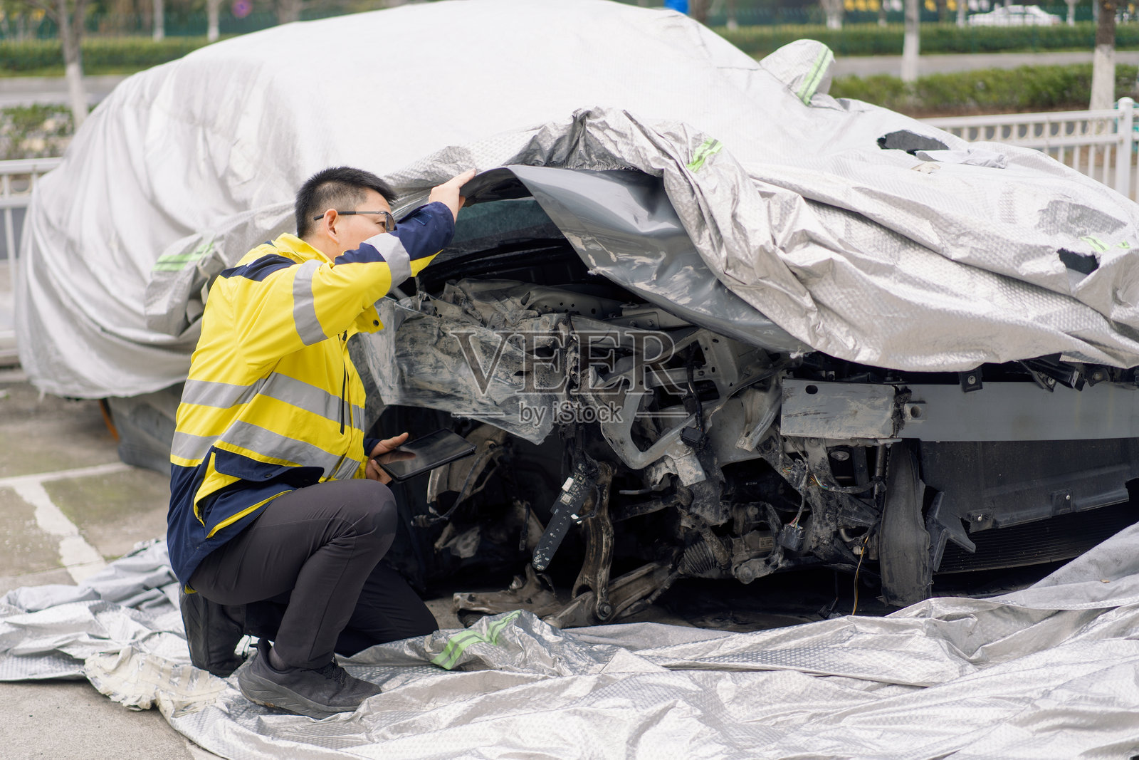 穿反光背心男子检查事故损毁车辆照片摄影图片