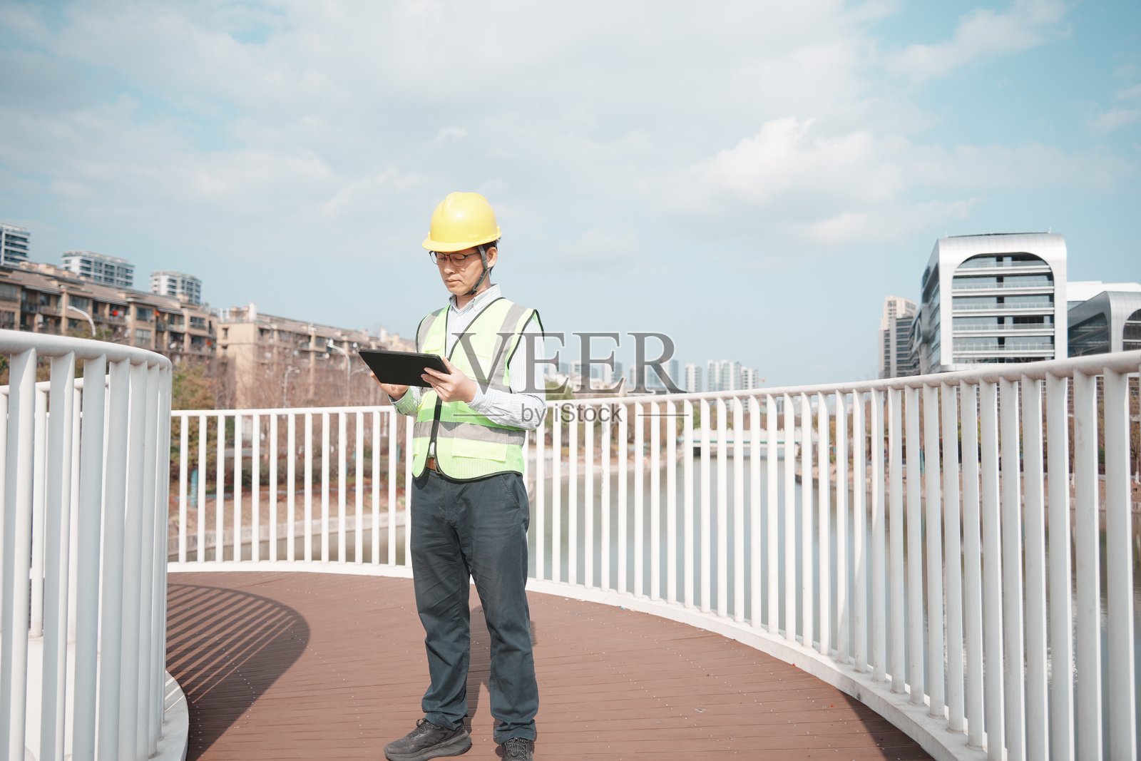 工程师戴安全帽持平板桥上巡检照片摄影图片