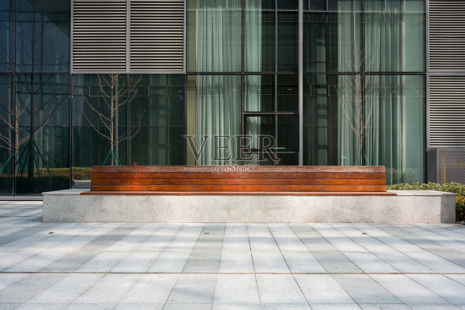 现代建筑前木质长凳与玻璃幕墙照片摄影图片